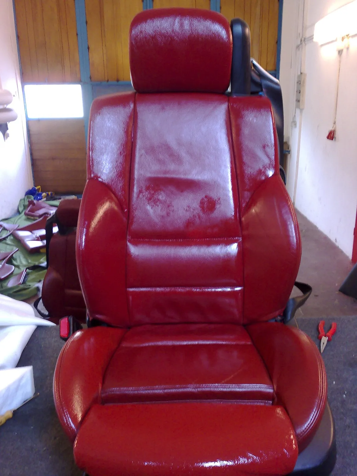 Roter Ledersitz nach der Aufarbeitung, gleichmäßige Farbe und Glanz